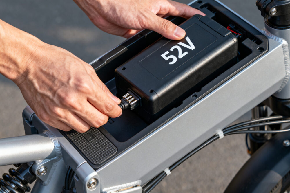 Hands installing 52V e-bike battery