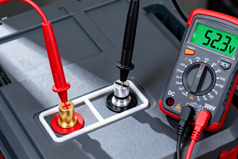 Multimeter checking voltage of 52V e-bike battery pack