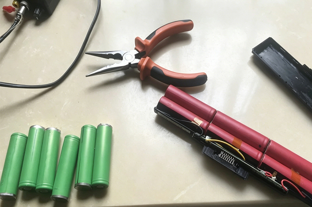 Opened laptop battery pack with multiple 18650 lithium-ion cells inside